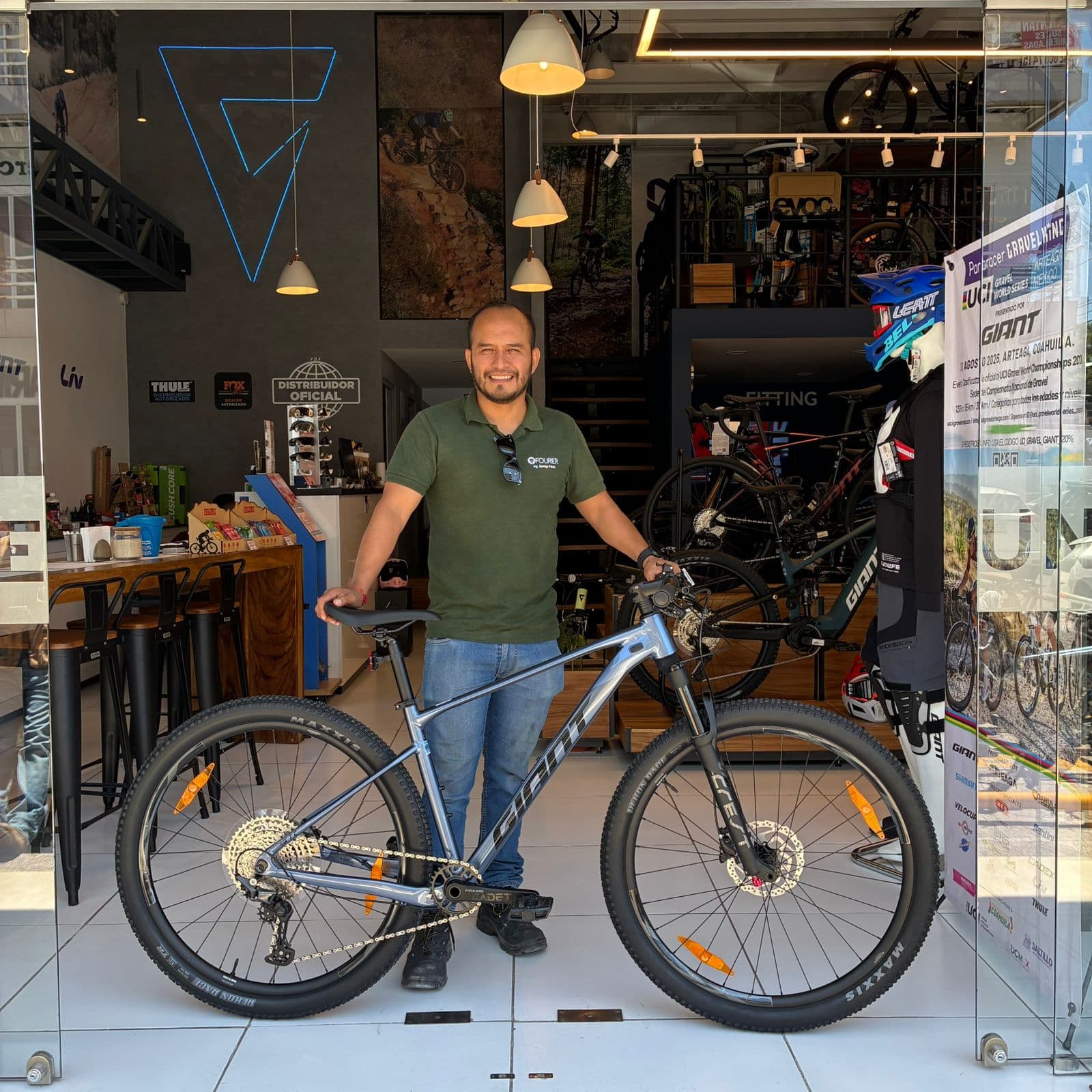 Cliente con su nueva bicicleta de montaña Giant gris en la entrada de la tienda Giant Juriquilla