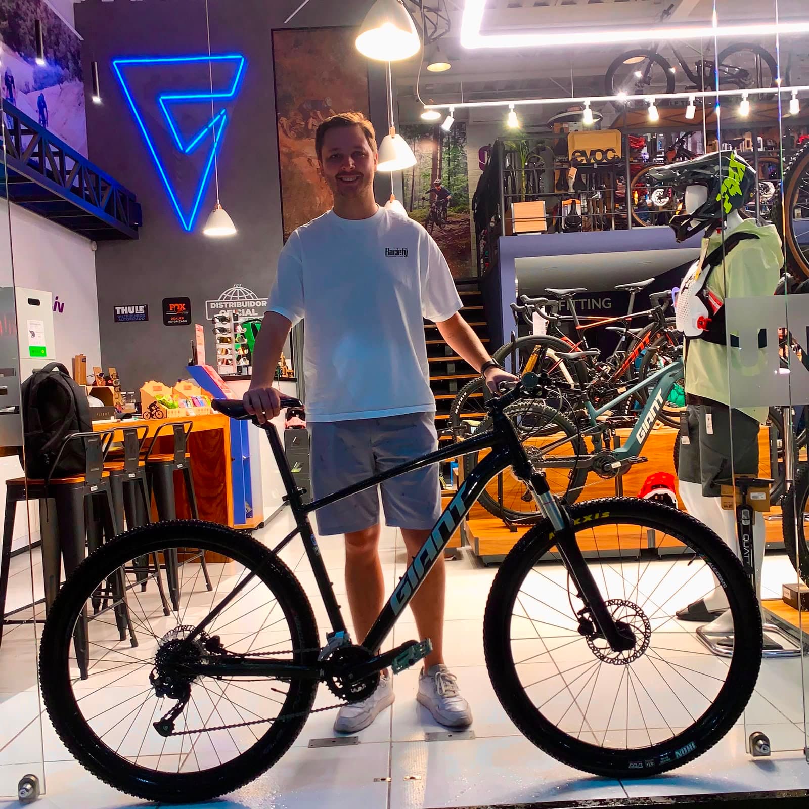 Cliente joven con su nueva bicicleta de montaña Giant negra bajo el logo de Giant Juriquilla