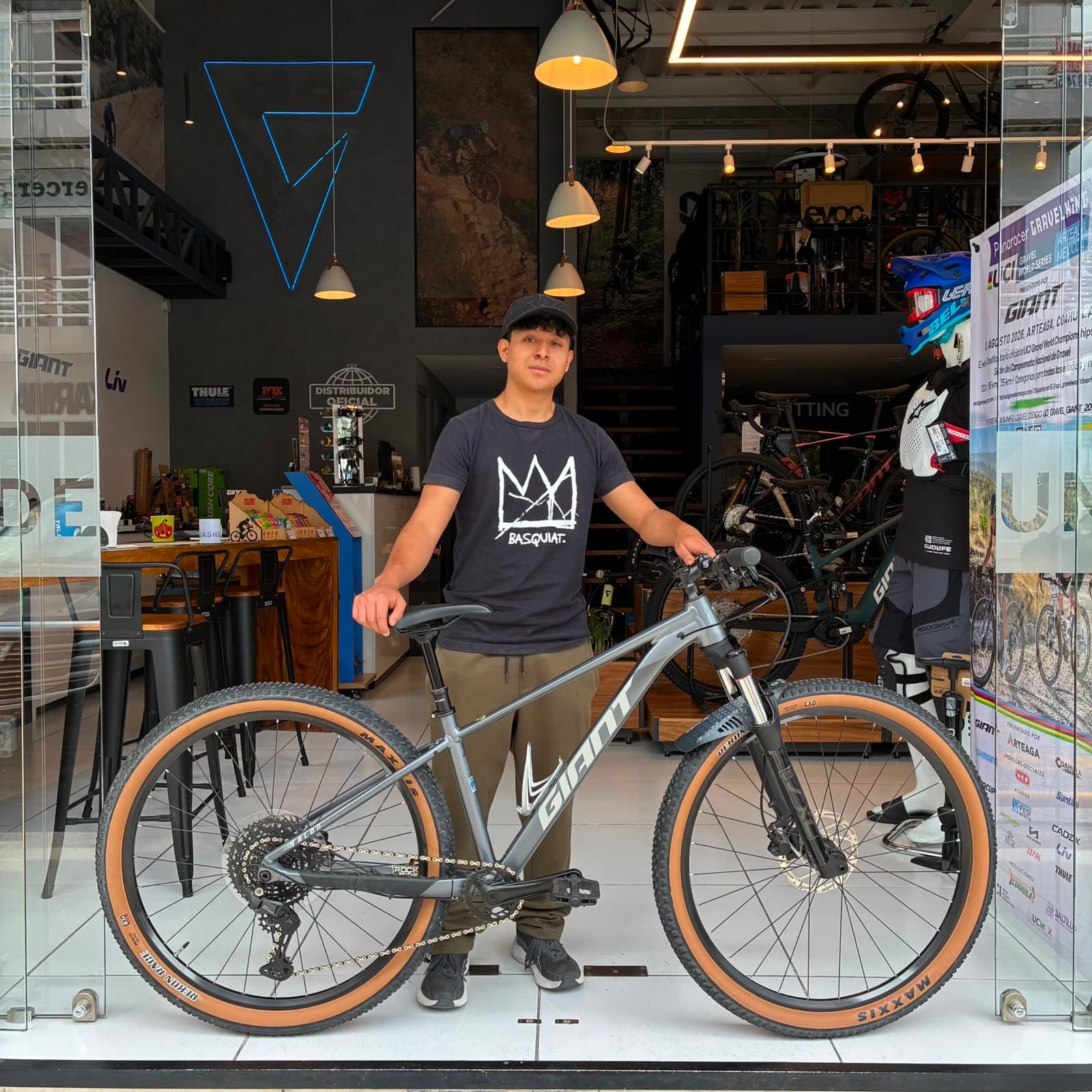 Cliente con su nueva bicicleta de montaña Giant gris en la puerta de la tienda Giant Juriquilla