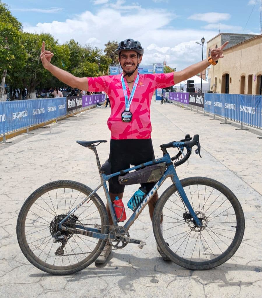 Ciclista de Giant Juriquilla celebrando con su medalla y su bicicleta gravel en la meta