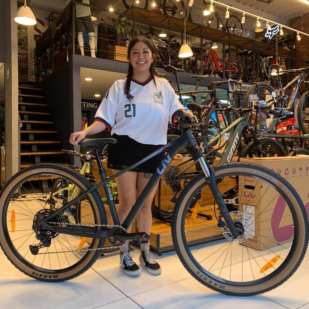 Cliente con su nueva bicicleta de montaña Giant negra junto al mostrador de Giant Juriquilla