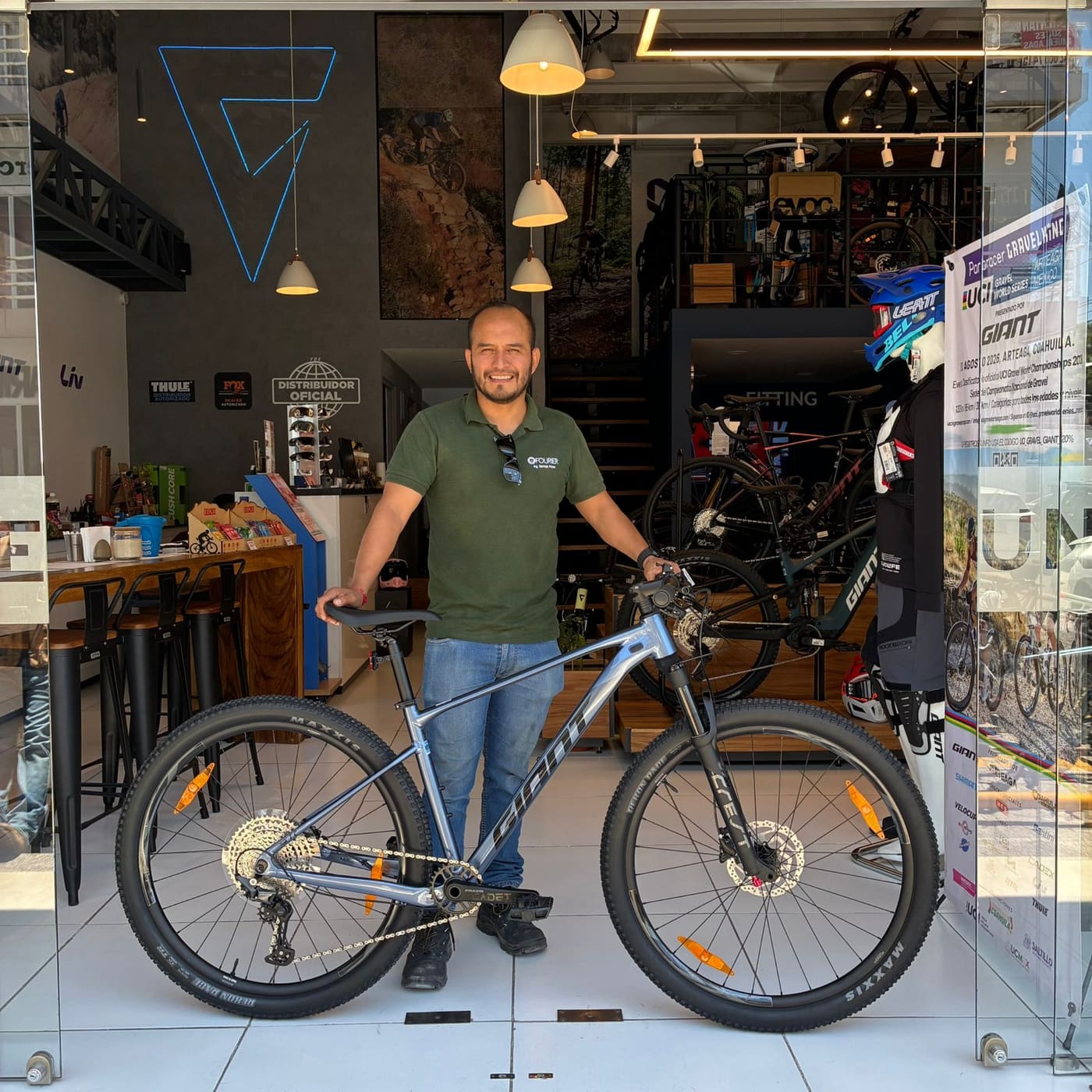 Cliente con su nueva bicicleta de montaña Giant gris en la entrada de la tienda Giant Juriquilla