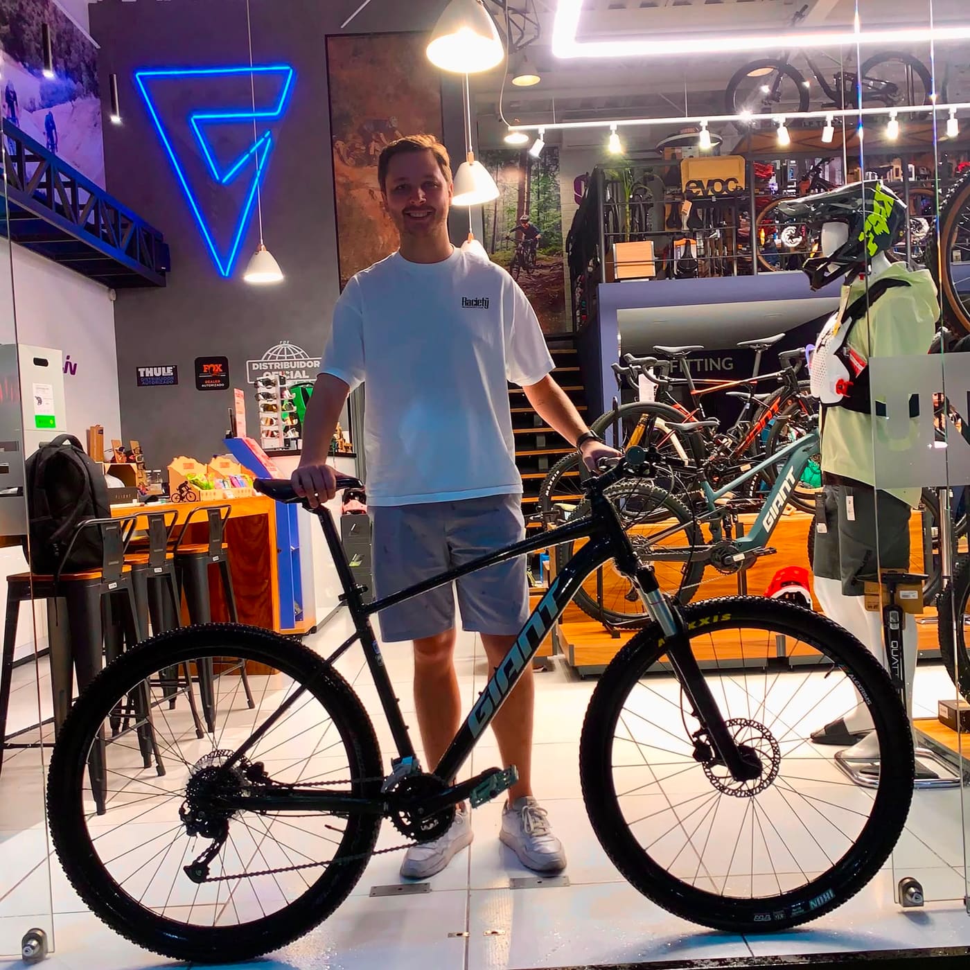 Cliente joven con su nueva bicicleta de montaña Giant negra bajo el logo de Giant Juriquilla