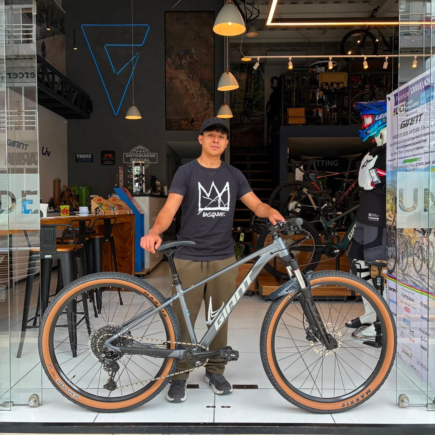 Cliente con su nueva bicicleta de montaña Giant gris en la puerta de la tienda Giant Juriquilla