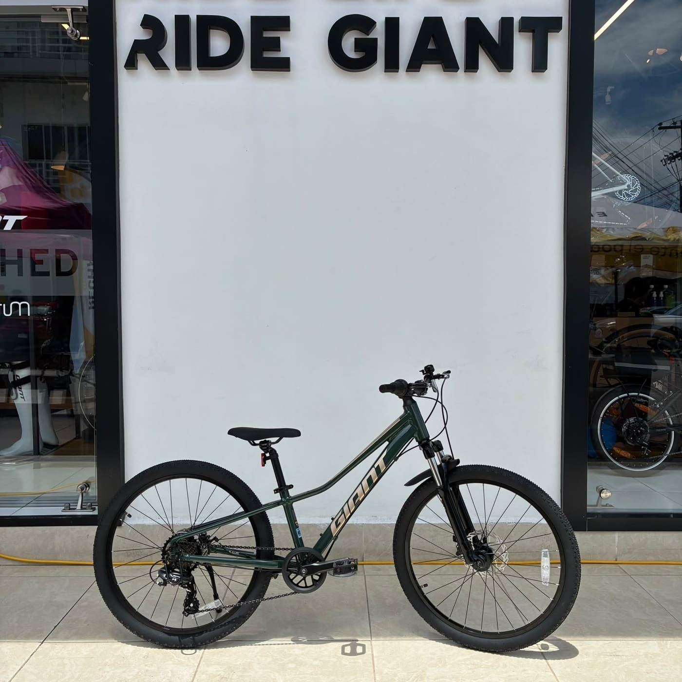 Nueva bicicleta Giant juvenil verde lista para entrega frente al mural Ride Giant