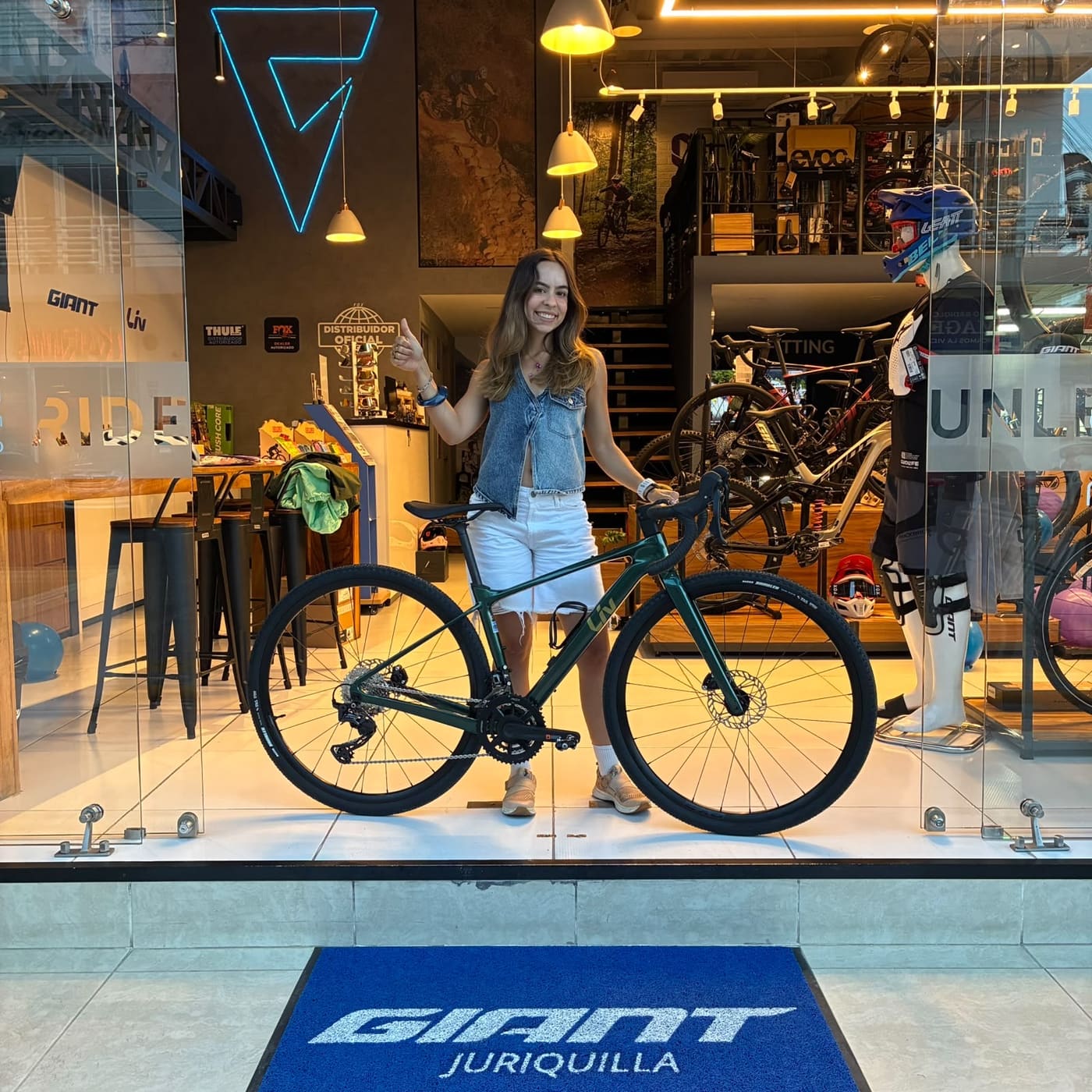 Cliente con su nueva bicicleta de ruta Giant en el ventanal de la tienda Giant Juriquilla