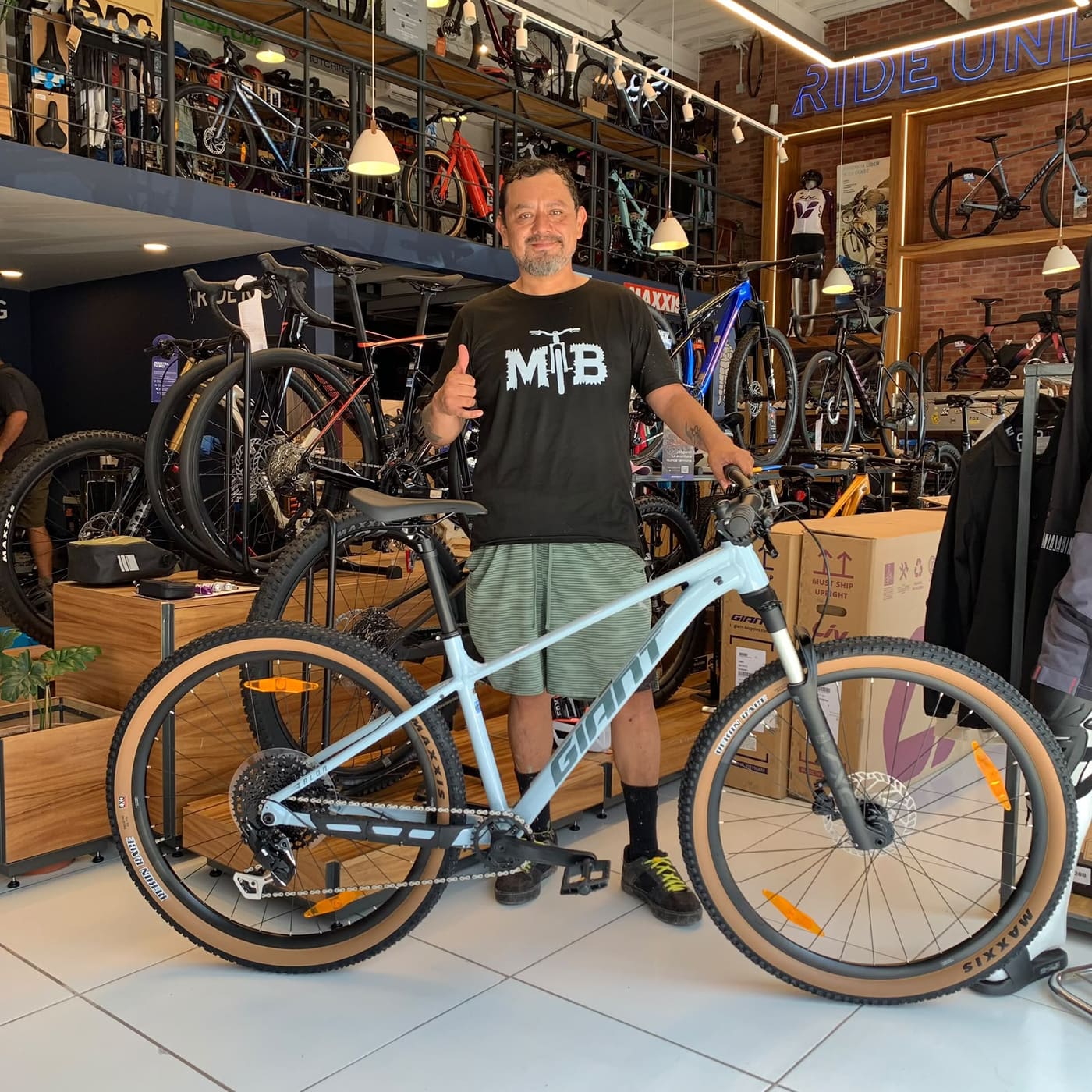 Cliente con su nueva bicicleta de montaña Giant azul claro en el interior de la tienda Giant Juriquilla