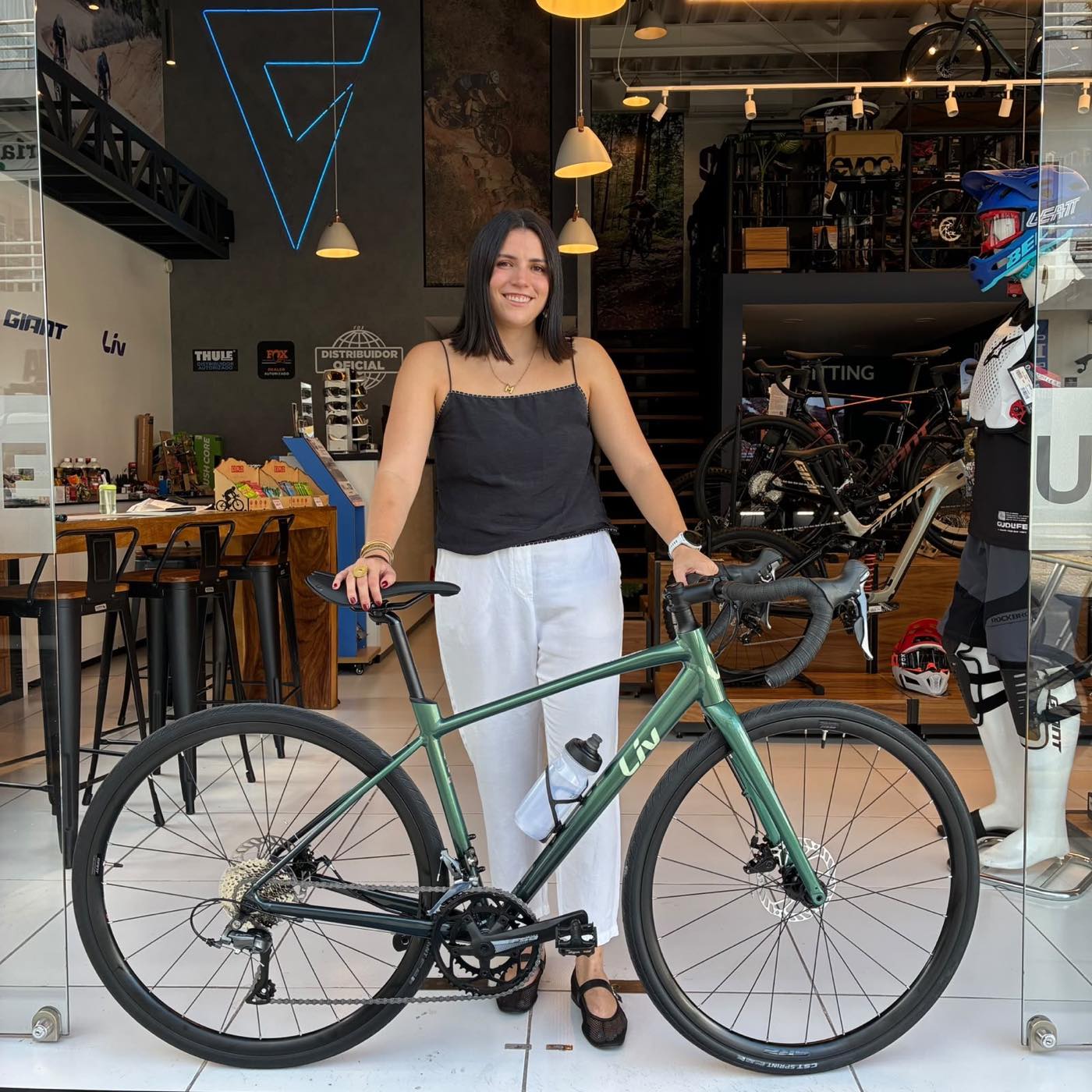 Cliente con su nueva bicicleta gravel Liv verde en el ventanal de la tienda Giant Juriquilla