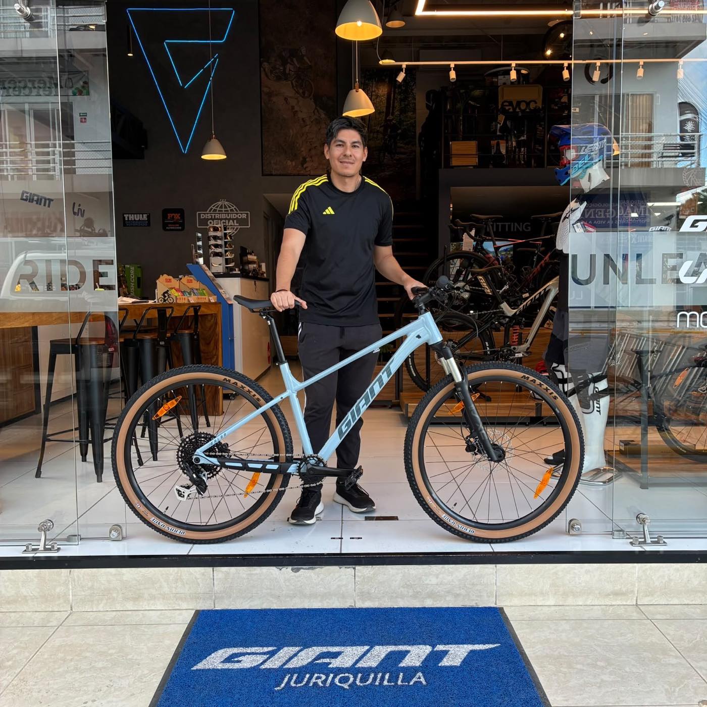 Cliente con su nueva bicicleta de montaña Giant gris claro sobre el tapete de Giant Juriquilla