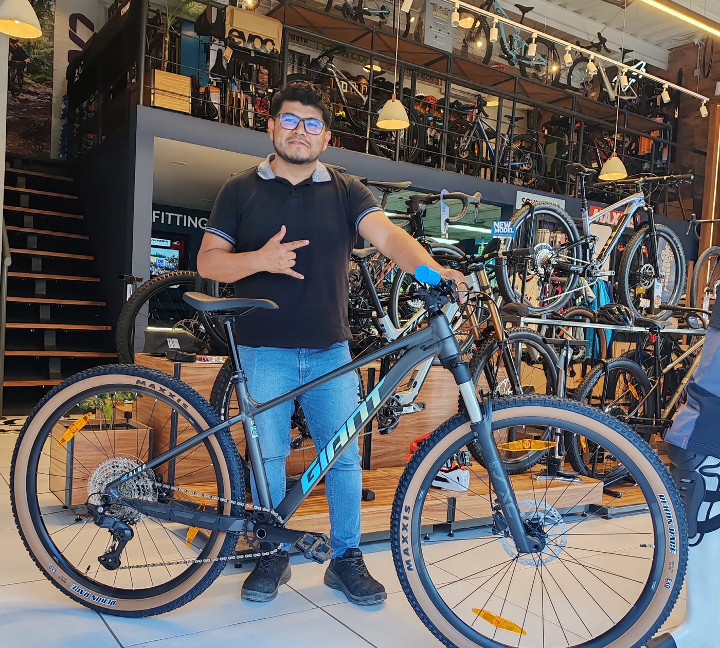 Cliente con su nueva bicicleta de montaña Giant gris junto al área de fitting de la tienda