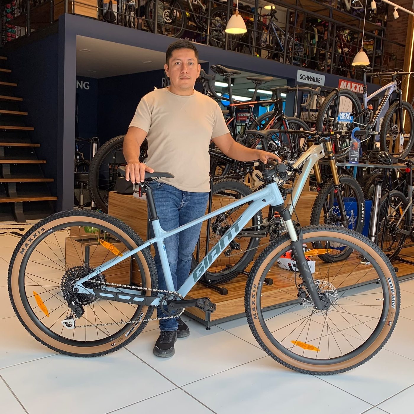 Cliente con su nueva bicicleta de montaña Giant azul claro dentro de la tienda