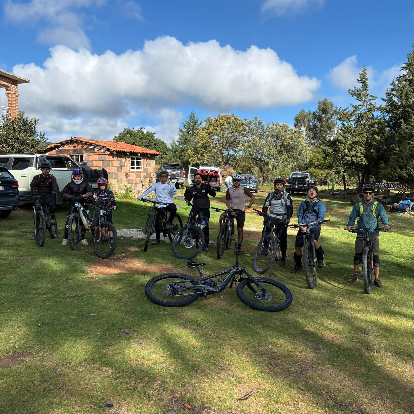 Grupo posando con sus bicicletas de montaña sobre el pasto al terminar la rodada