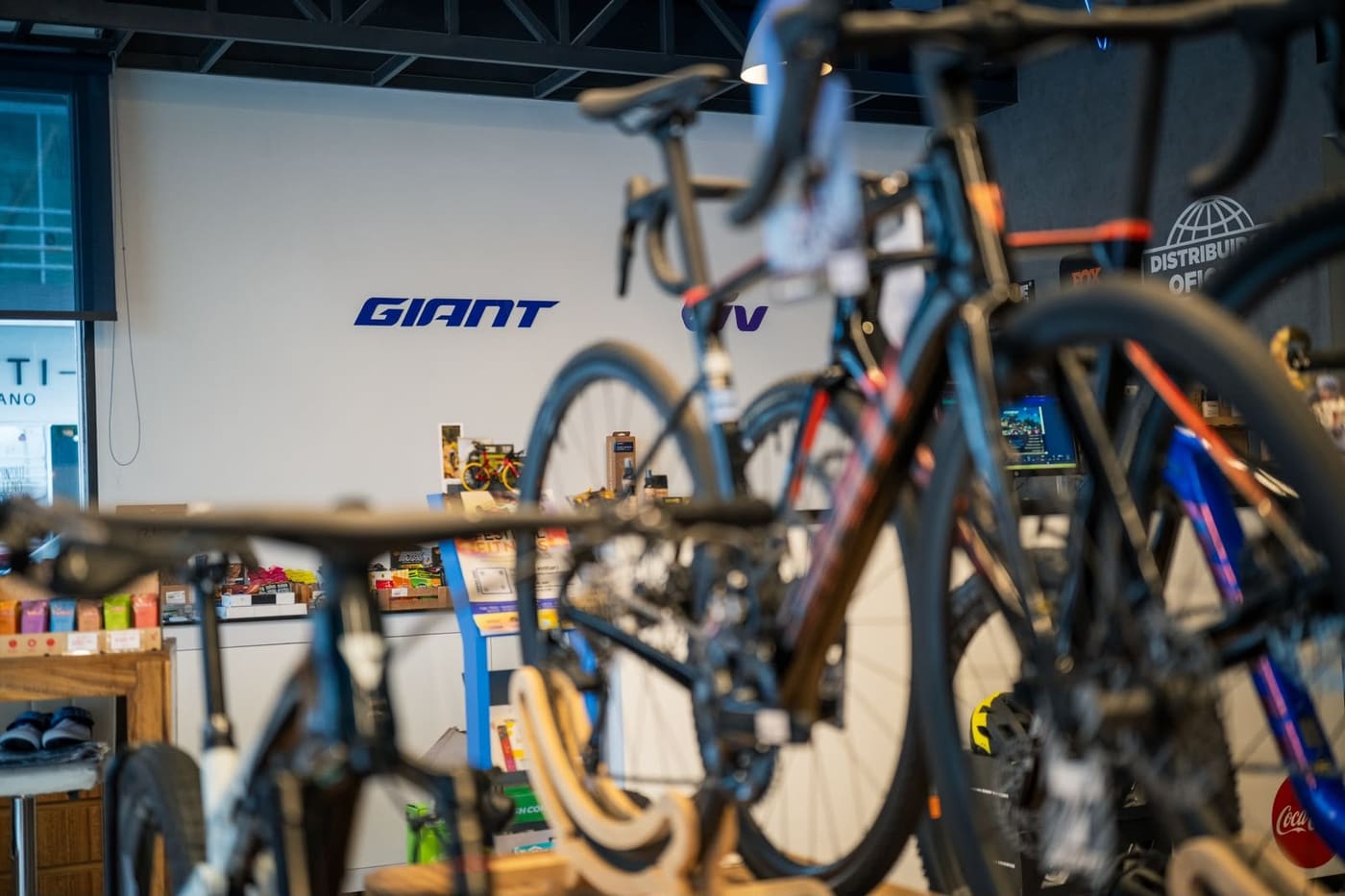 Logotipo de Giant en la pared del piso de venta, con bicicletas de ruta en primer plano