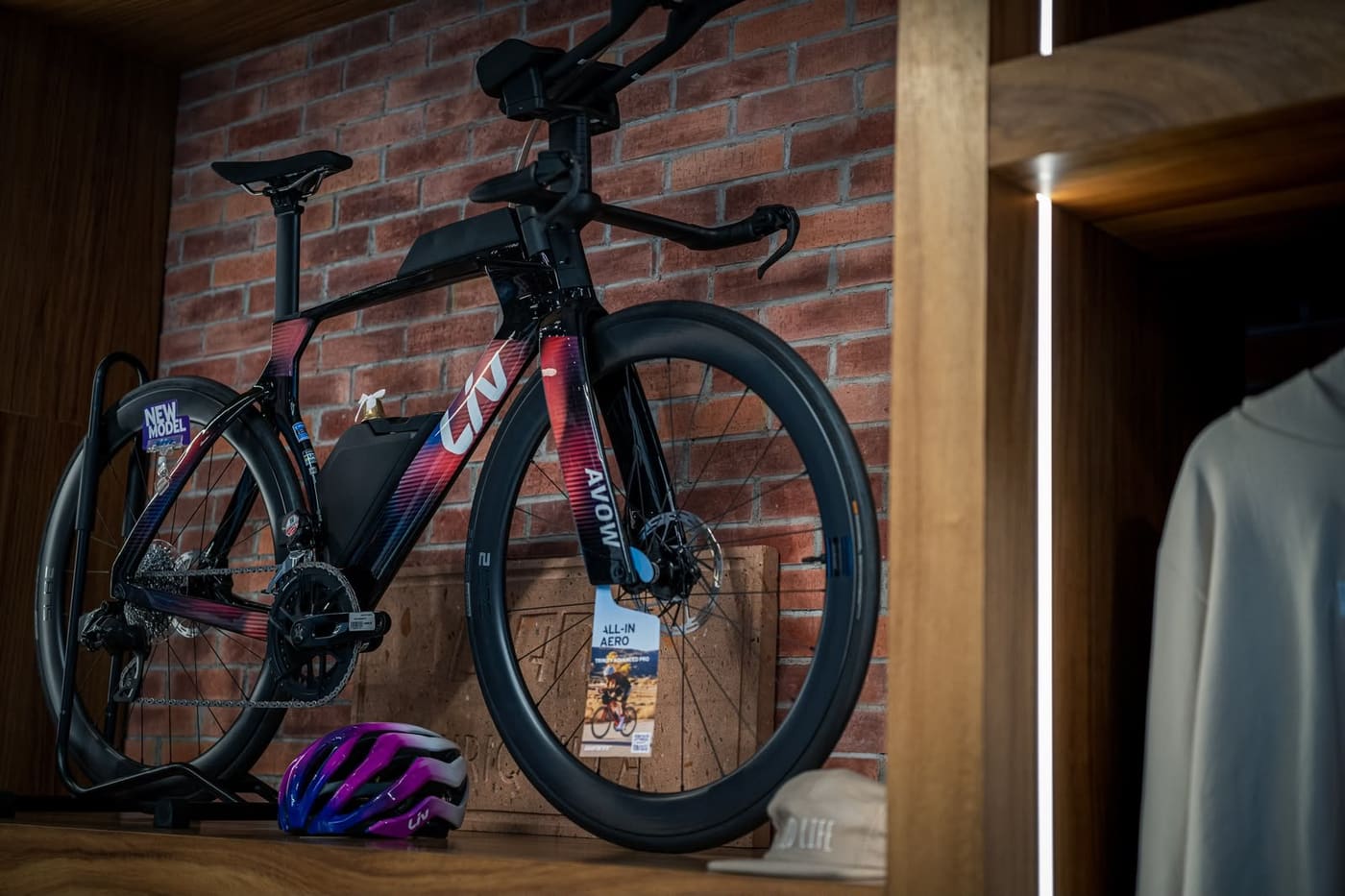 Bicicleta de ruta Liv apoyada en el muro de ladrillo junto a la sección de ropa