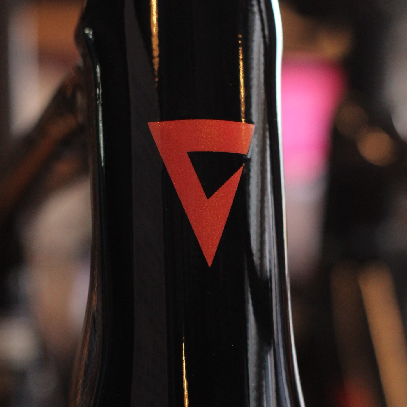 Detalle del logotipo Liv en rojo sobre el cuadro negro brillante de una bicicleta