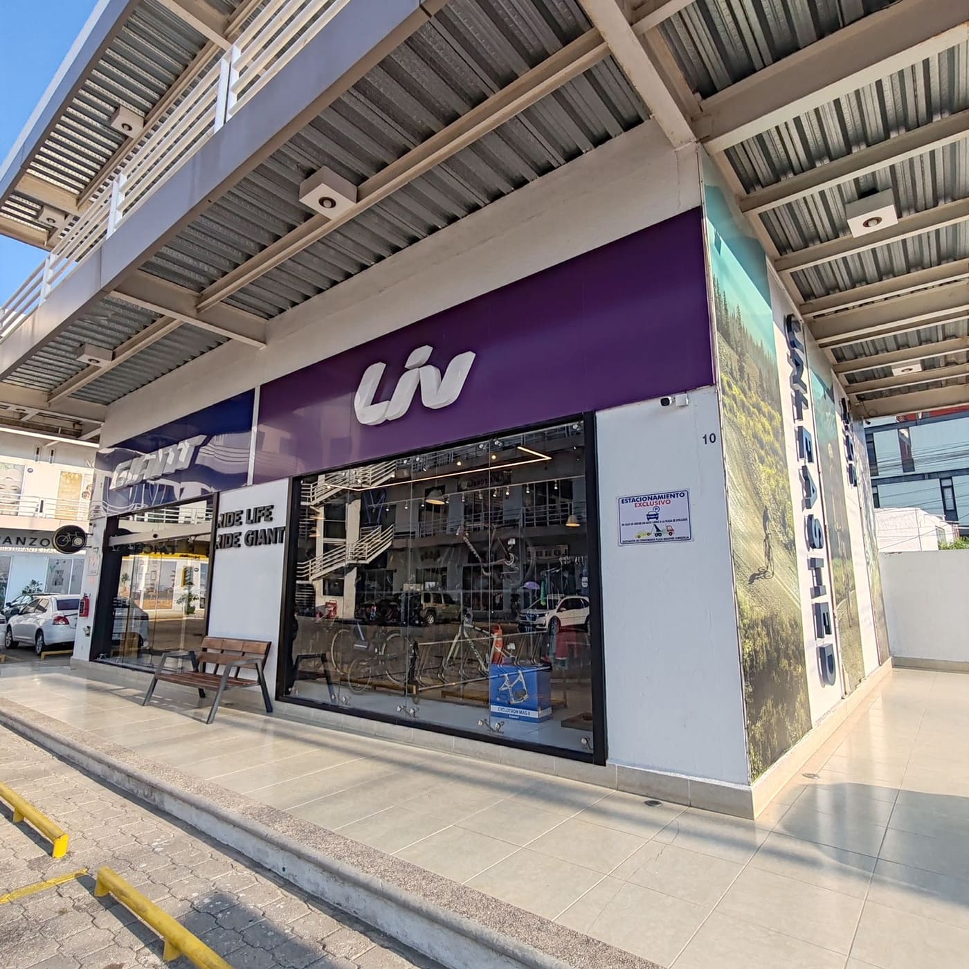 Entrada de la sección Liv con la banca de madera en la banqueta de la tienda