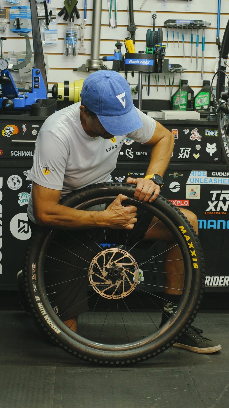 Mecánico de Giant Juriquilla montando una llanta Maxxis sobre el rin de una bicicleta de montaña
